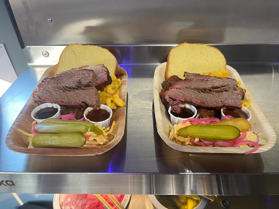 Two loaded brioche buns on serving boards