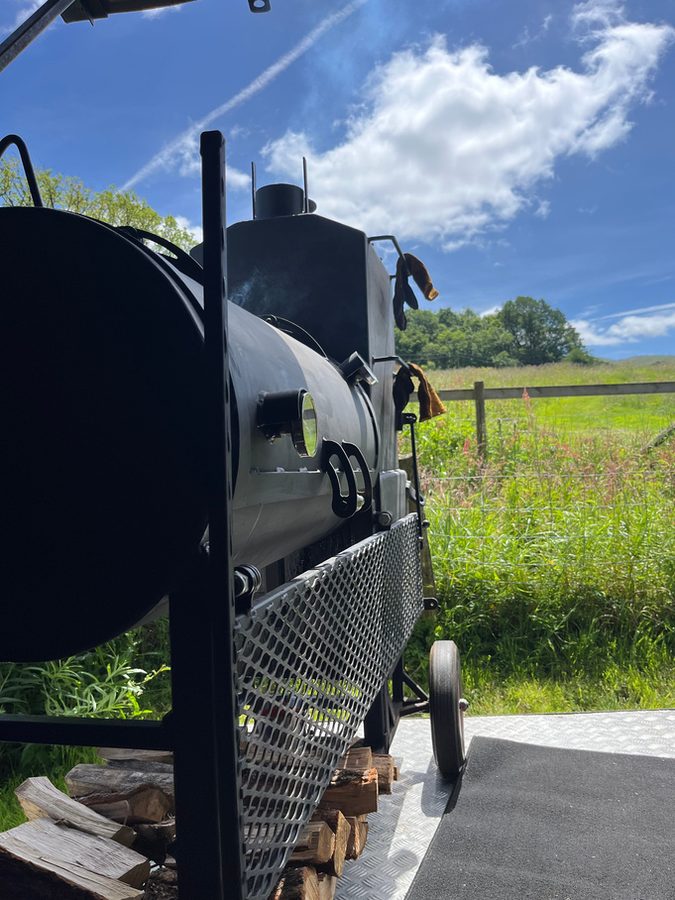 The Bear Pit smoker trailer parked in a green Welsh field
